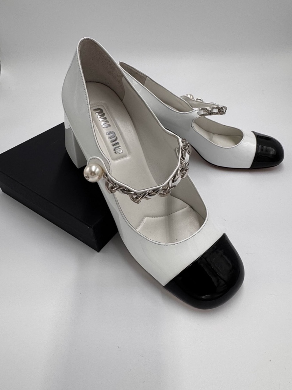 Miu Miu White Leather Mary Janes with Black Cap Toe and Pearl-Accented Chain